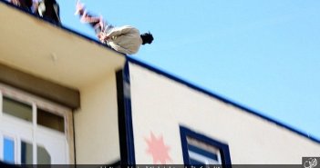 Bound man being hurled off the top of a building after he was accused of being gay