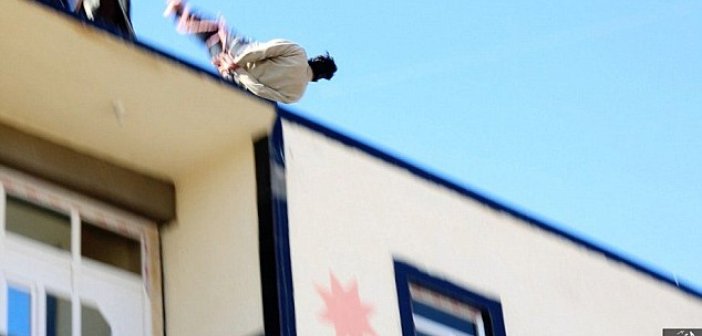 Bound man being hurled off the top of a building after he was accused of being gay